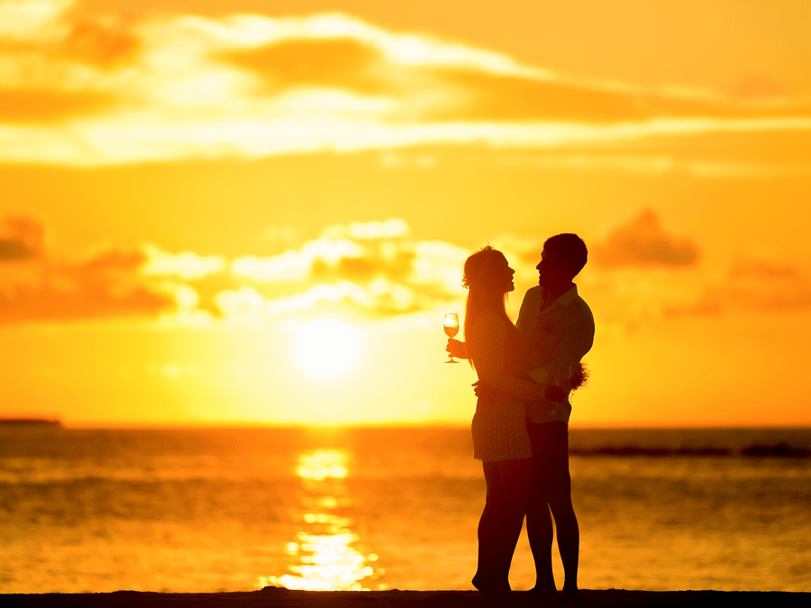 Silhouette of a couple holding each other on a beach at sunset, capturing an Andaman and Nicobar Islands destination wedding moment.