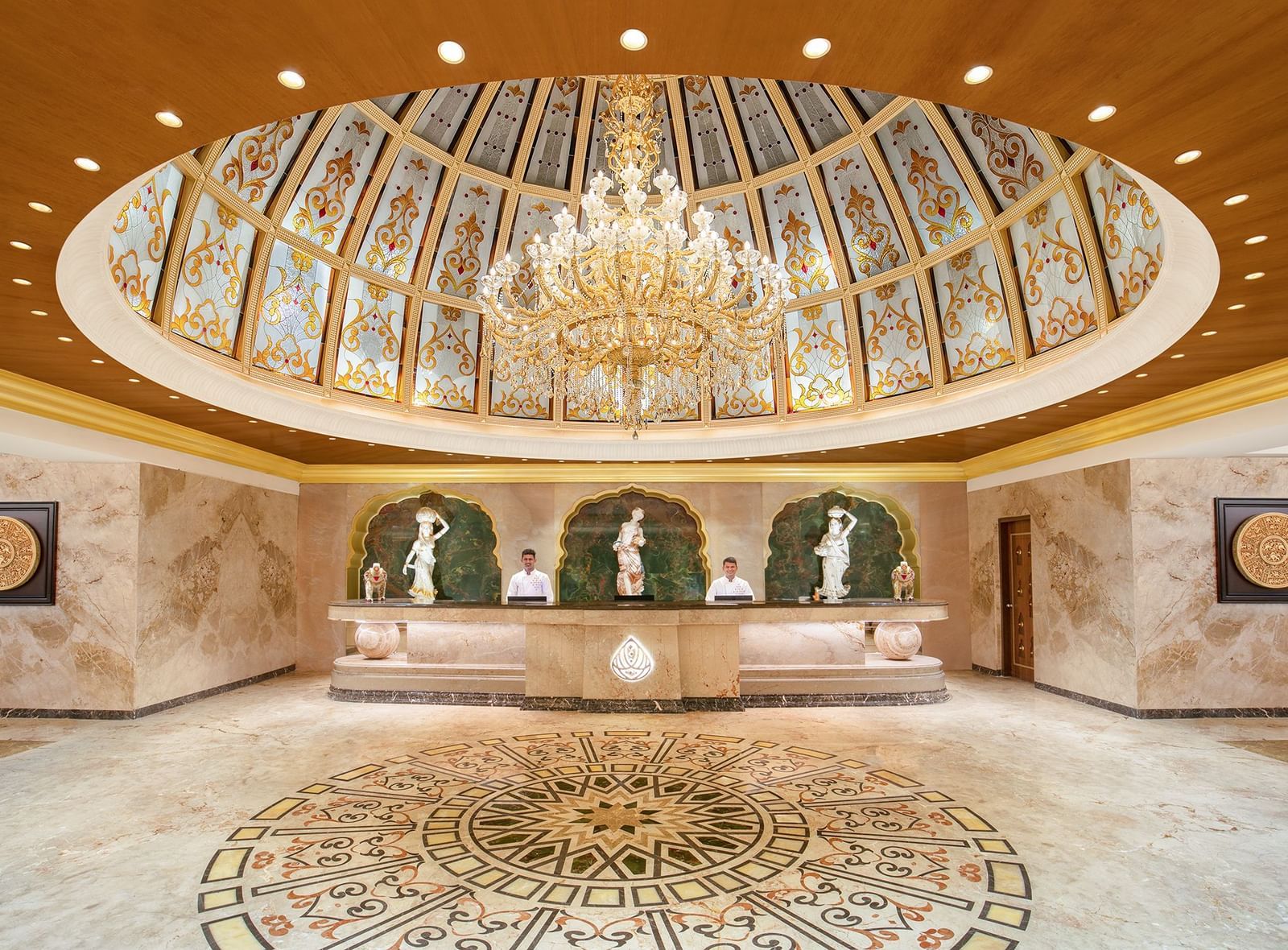 A reception area with a reception desk, receptionists and a giant chandelier - Kaldan Samudhra Palace