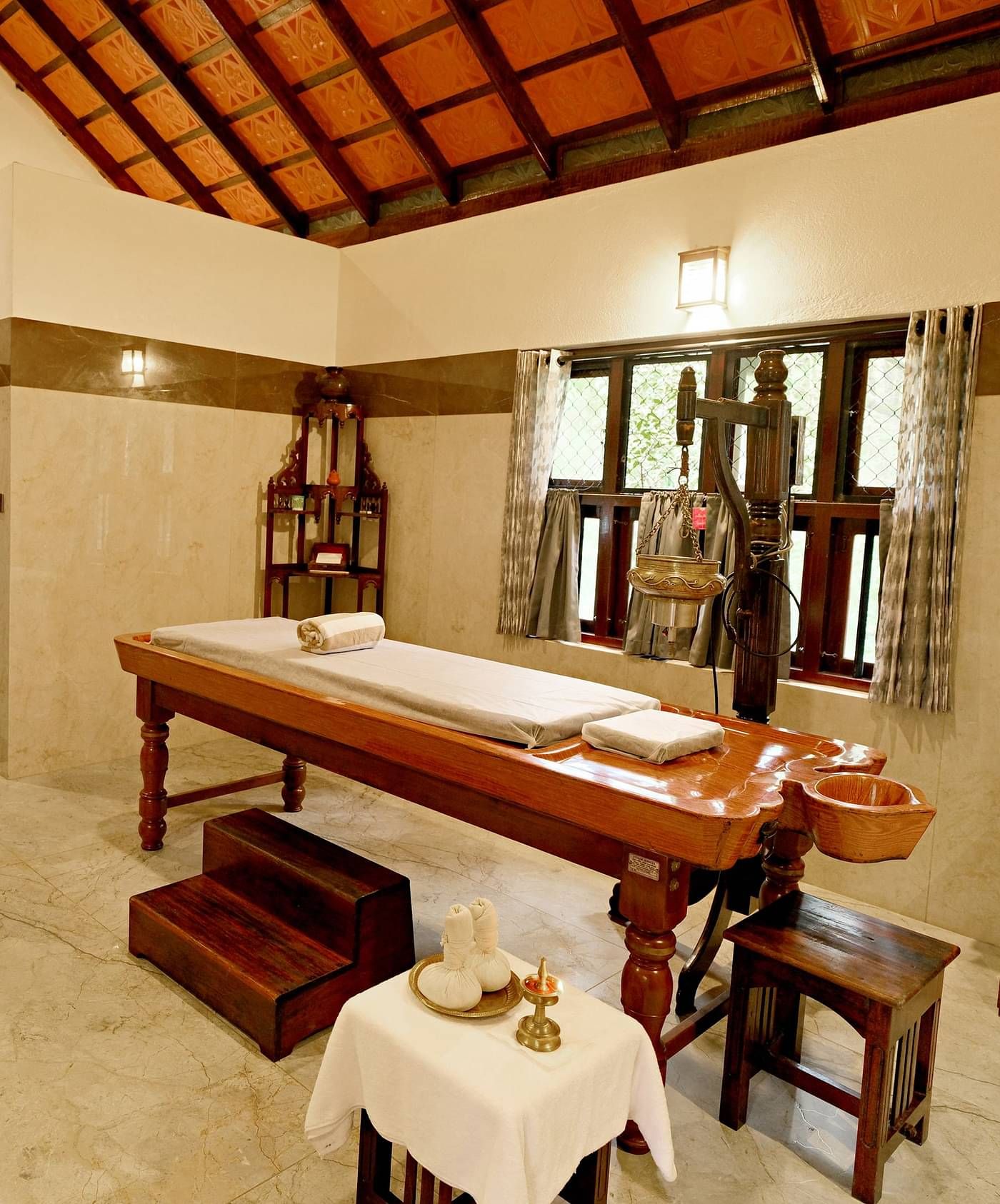 Spa room with massage beds and wooden decor at Vythiri Resort, Wayanad