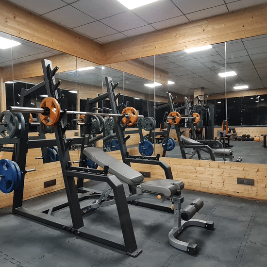 Modern gym equipment at Shaheen Bagh, set in a sleek mirrored workout space.