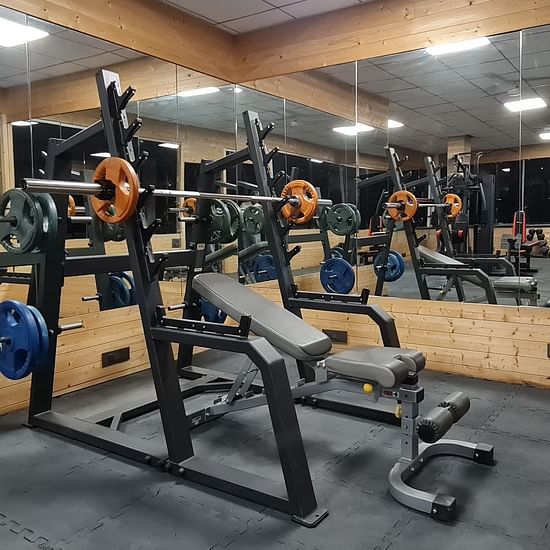 Modern gym equipment at Shaheen Bagh, set in a sleek mirrored workout space.