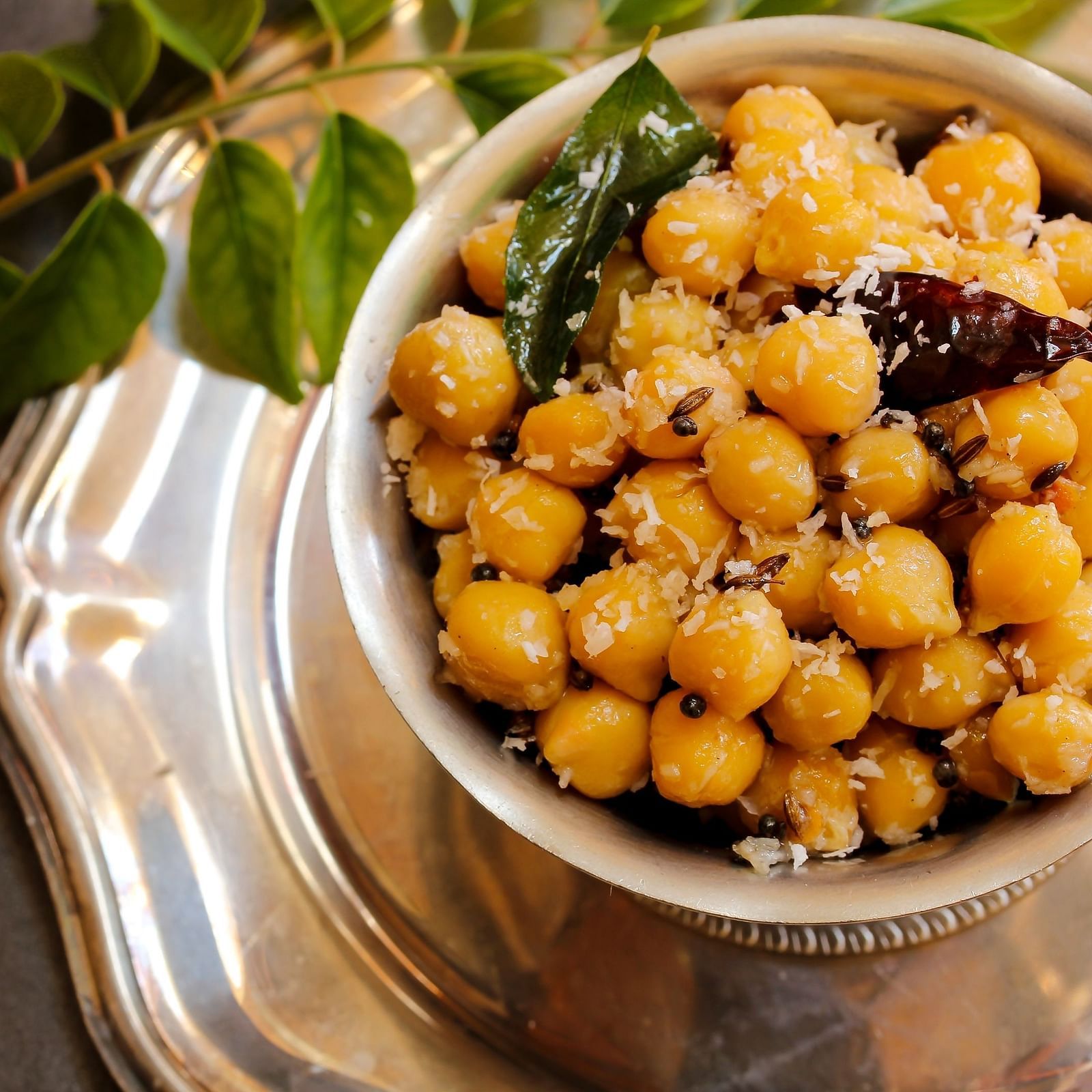 A bowl of seasoned chickpeas (chana) with curry leaves, a popular savoury Indian snack.