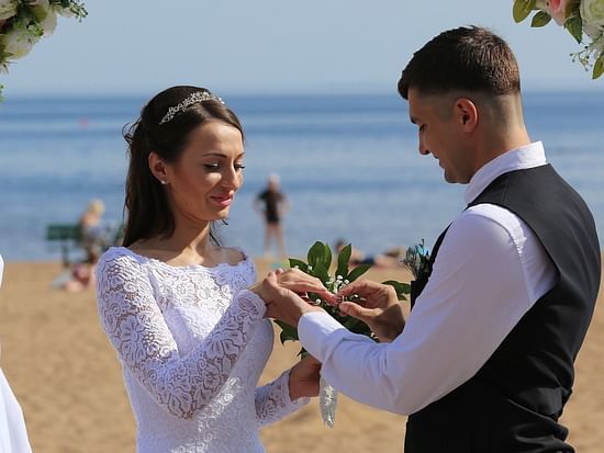 alt-text Groom placing wedding ring on the bride at a beach wedding in Andaman