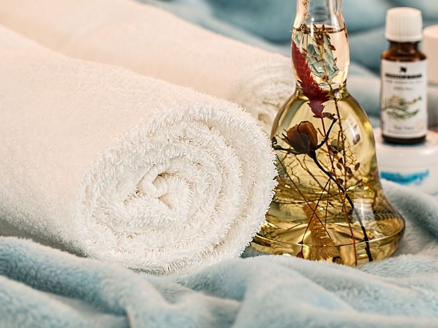 towels and essential oils kept on top of a blanket
