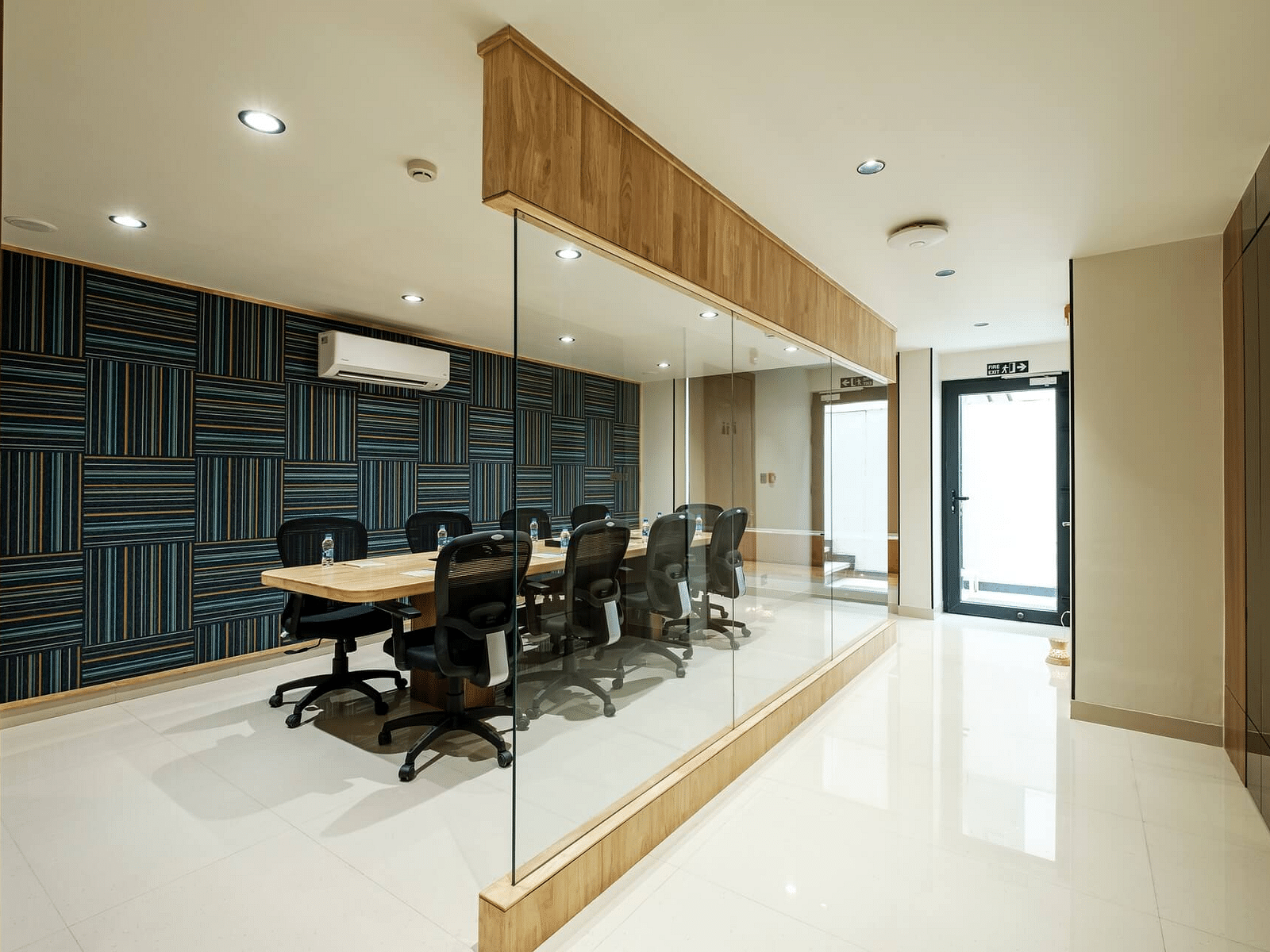Conference room at Indie Stays, Jaipur, with a rectangular table and chairs arranged around it, visible through a glass partition.