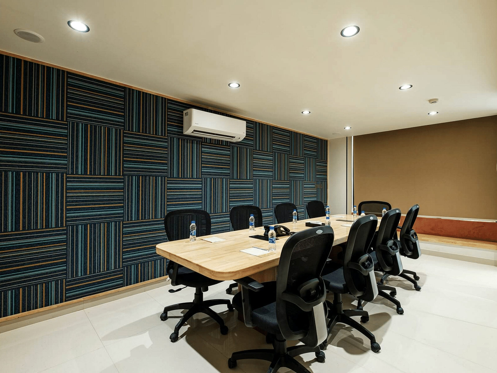 Diagonal view of the conference room at Indie Stays, Jaipur, with a large table and chairs arranged around it.