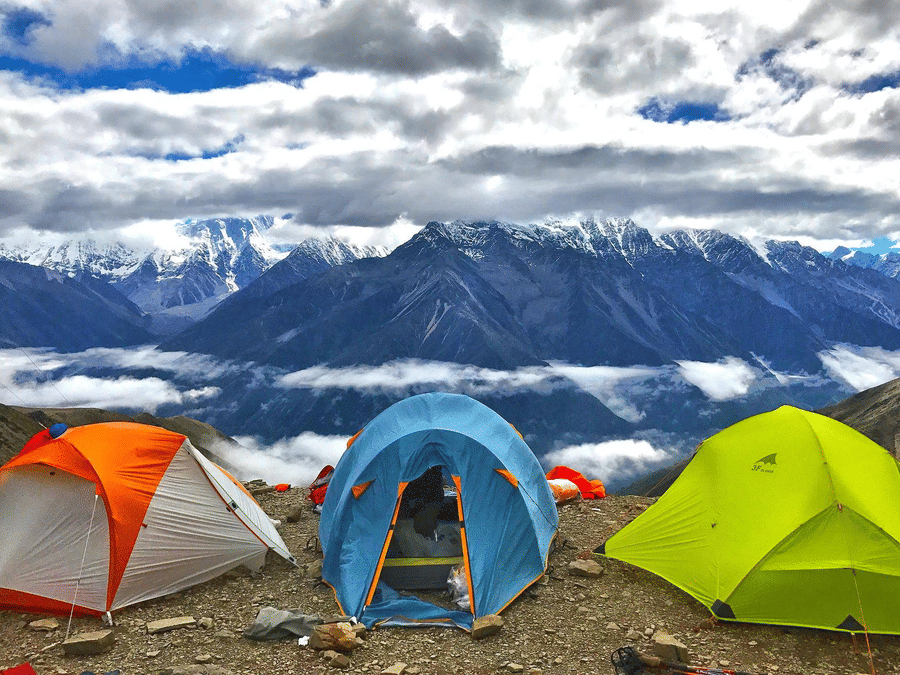 camping tents overlooking snow-capped mountains