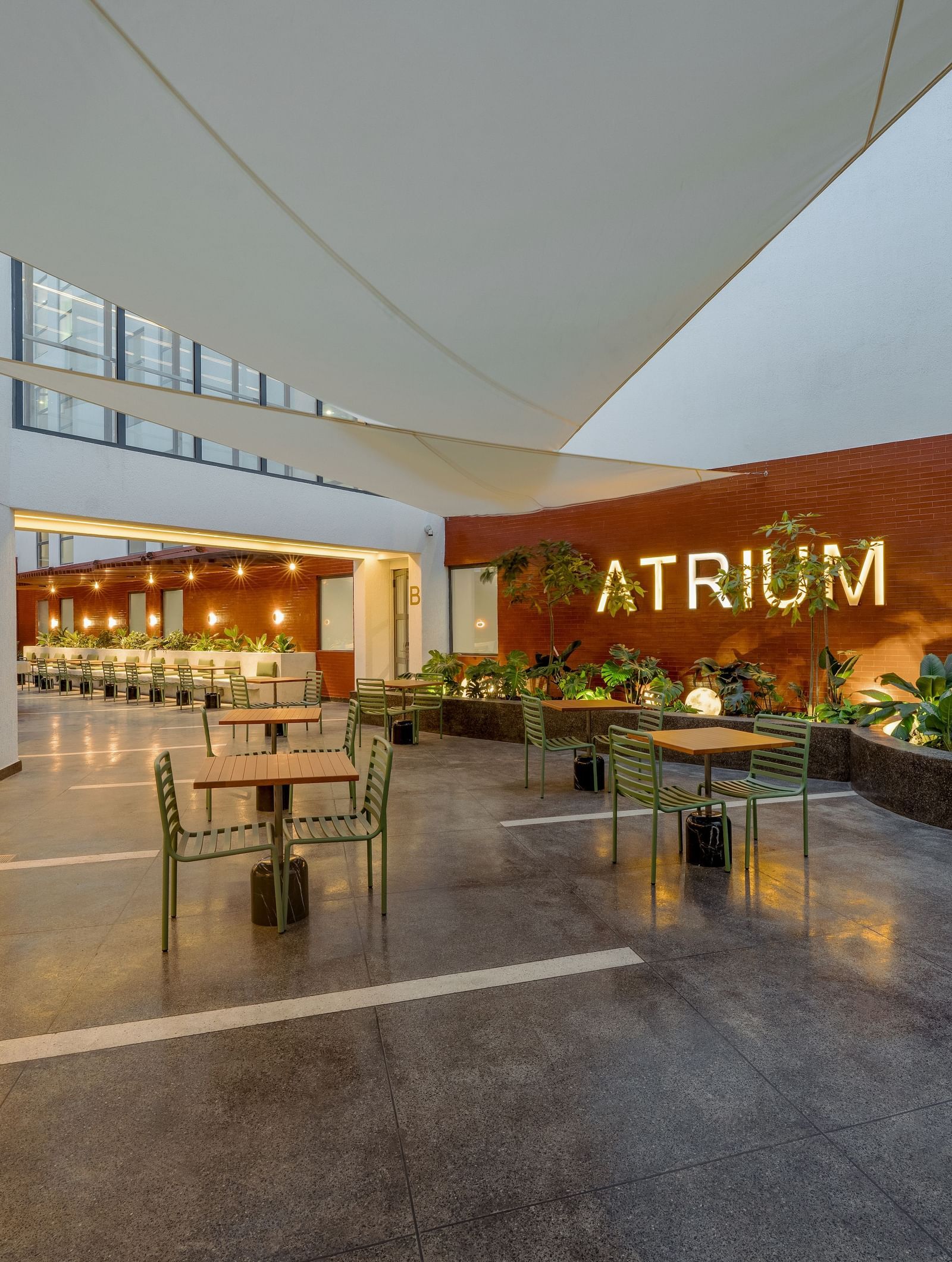 Modern open-air design of Atrium restaurant at The Pelican Hotel, Accra, with greenery and stylish decor.