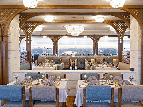 A bright, open-plan restaurant with multiple tables and elegant blue and white decor, part of accommodation in Lucknow - Clarks Avadh, Lucknow