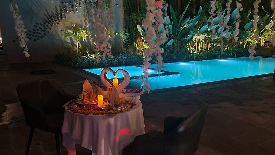 Guests enjoying an outdoor meal with fresh flowers and a beautifully arranged table setting on a private balcony - Sea Hills Resort, Swaraj Dweep (Havelock)