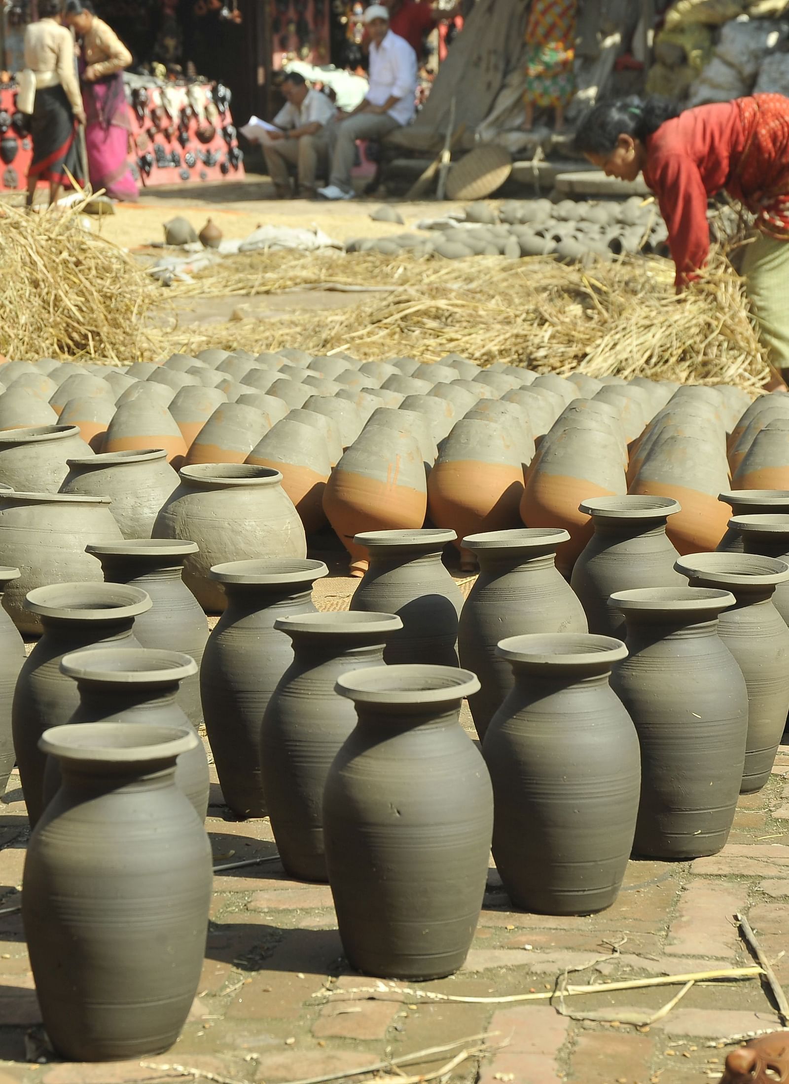 A pottery lined up on a ground which are kept for drying under the sun