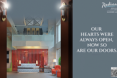 Elegant hotel lobby with modern decor and a vibrant red accent wall.