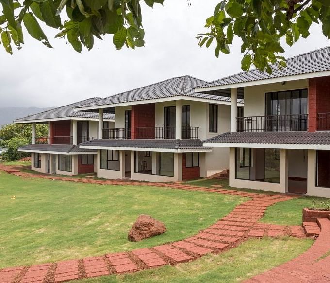 Exterior view of Forest Escapes Resort framed by tree leaves.