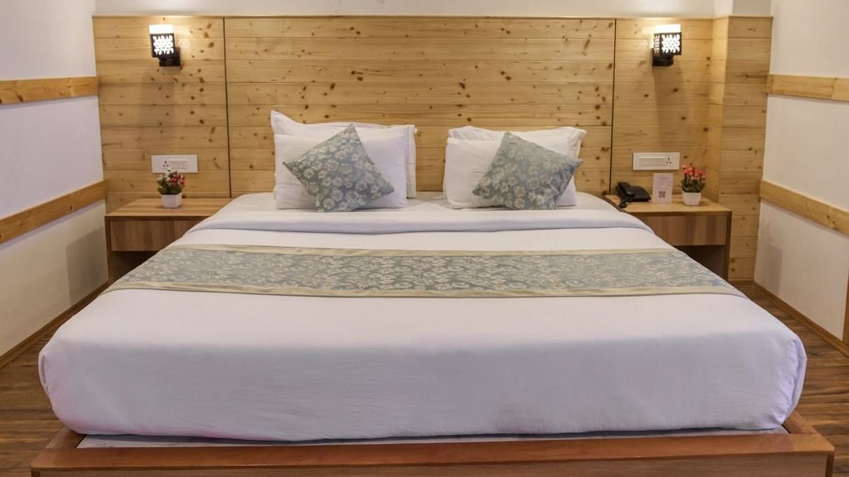 Standard Room at Avianna Gangtok Prime Hotel & Spa featuring a plush bed under warm lighting and two nightstands on both sides with a lamp above each