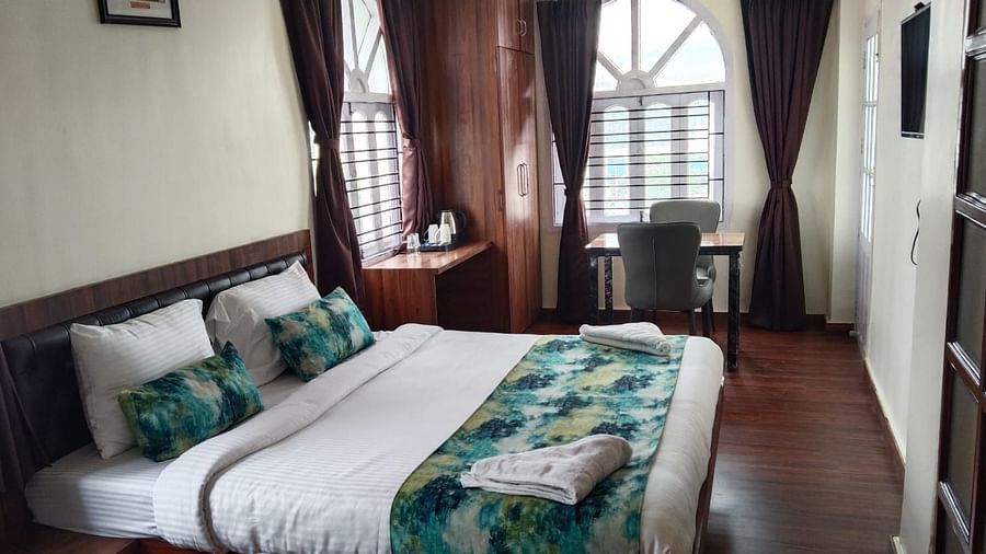 A double bed with towels kept on them inside Premium room with balcony - Ecotel Kolkata