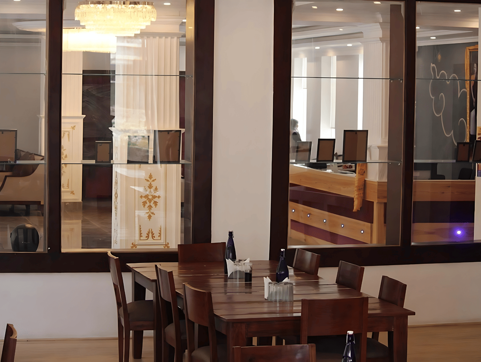 View from the dining area toward the reception desk through large glass partitions at Hotel Dekiling by Eastlynn Collections, Leh.