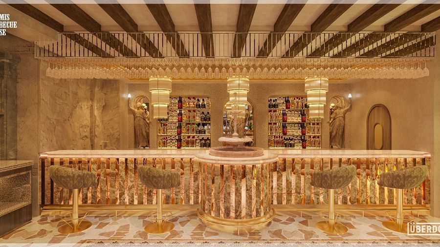 A stylish bar area with a modern golden theme and intricate decorative elements at Themis Barbecue House, Ambience Mall, Gurugram