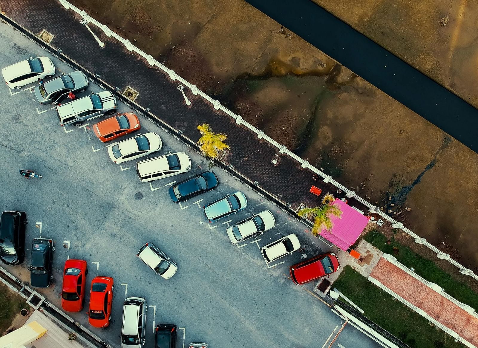 An aerial view of a parking lot with cars parked beside each other.