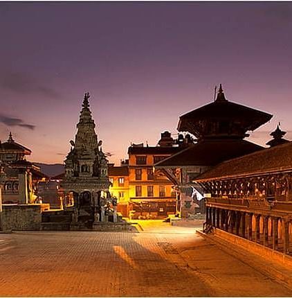 An overview of Bhaktapur Durbar Square in the night with the lights on during the twilight sky