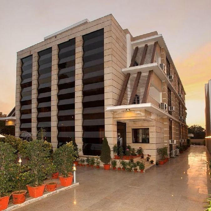 Exterior view of Five Elements Hotels The Claire, Gurugram, showcasing the modern facade and entrance area at sunset