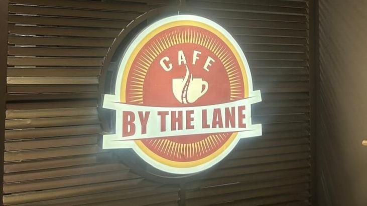 A close-up of a wooden door with the OnTime Hotel logo at The OnTime Hotel, Bangalore.