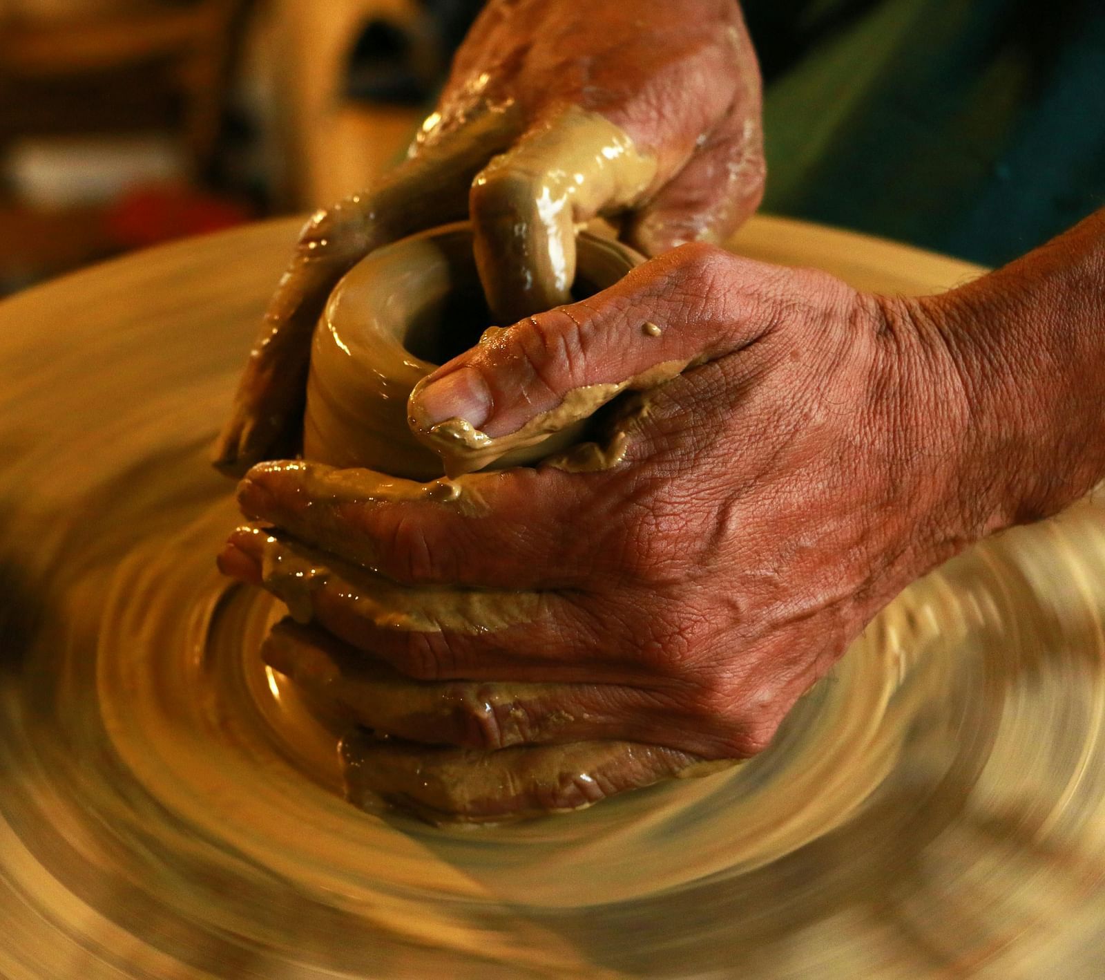 Selective focus photography of a person molding clay.