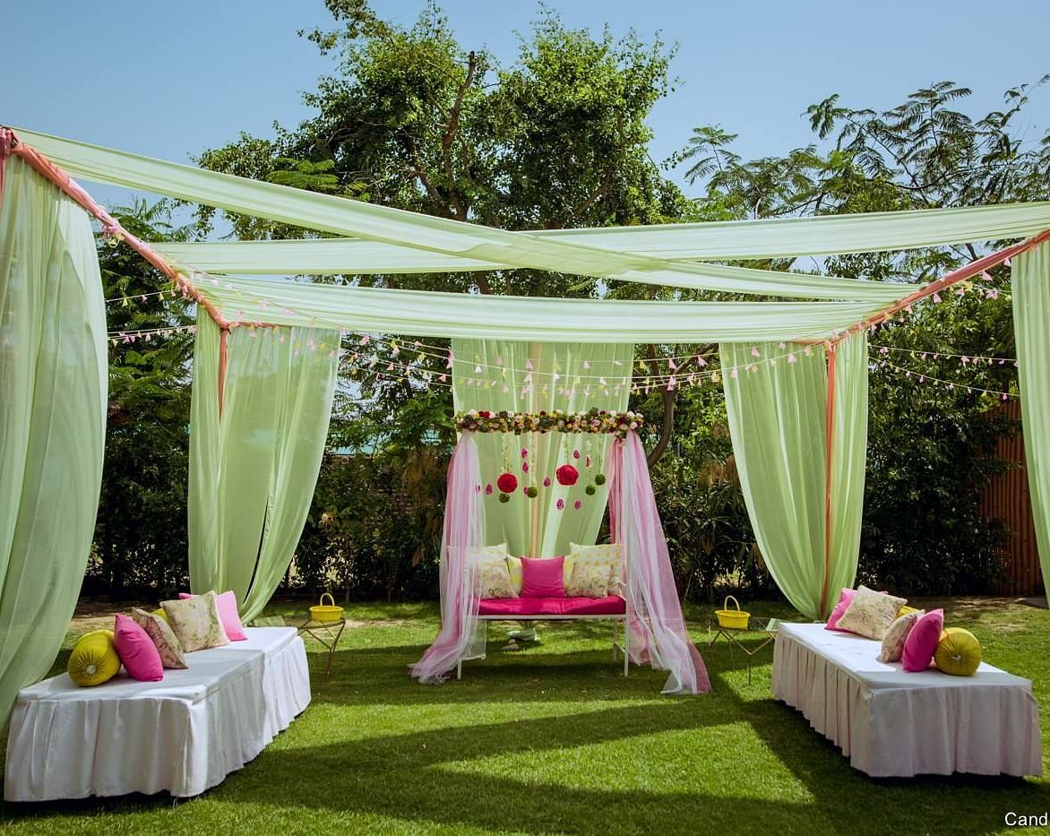 Outdoor wedding mandap with floral decorations and a view of the hills.
