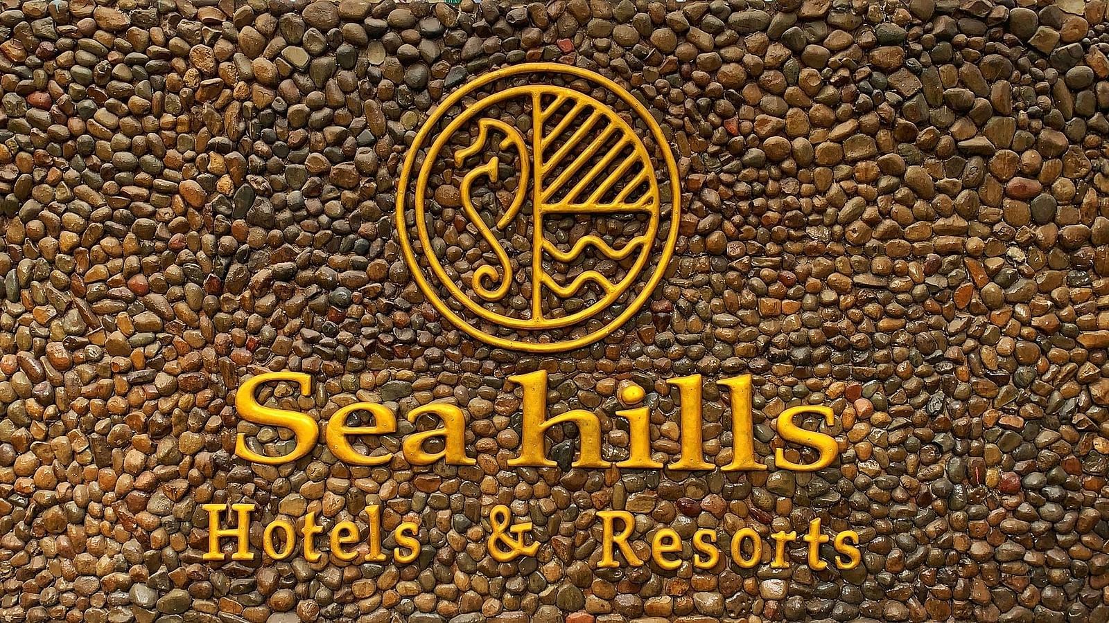 Seahills Hotels & Resorts logo on a stone wall background