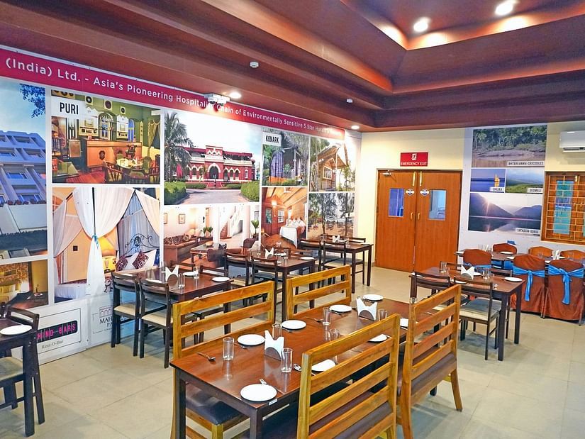 Well-lit Vithal Kamat restaurant interior with family-friendly seating and vivid wall art
