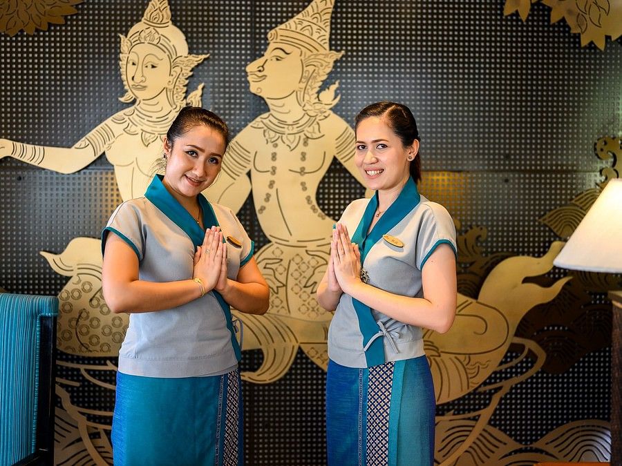 alt-text image of two staff members posing for a picture with their hands joined to greet the guests - Maikhao Dream Villa Resort & Spa, Phuket