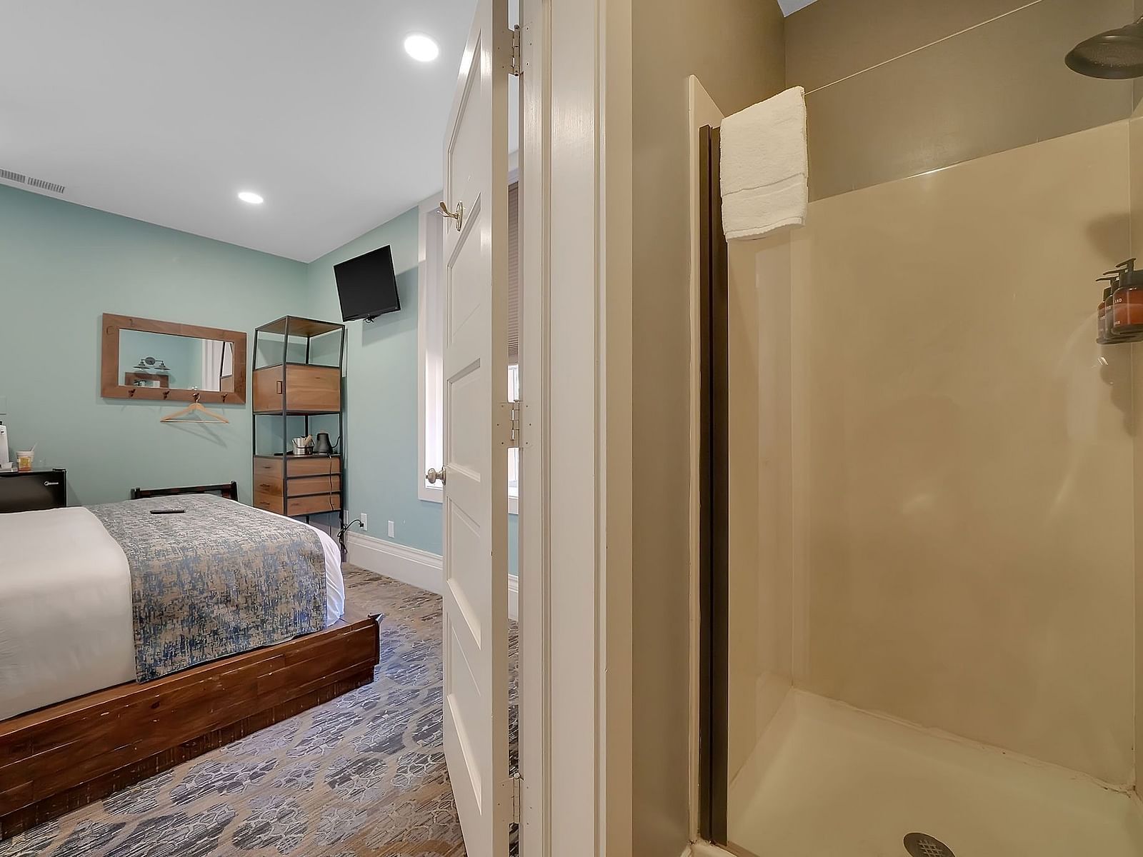 view of a double bed and the ensuite bathroom in one of the rooms at The Groveland Hotel.