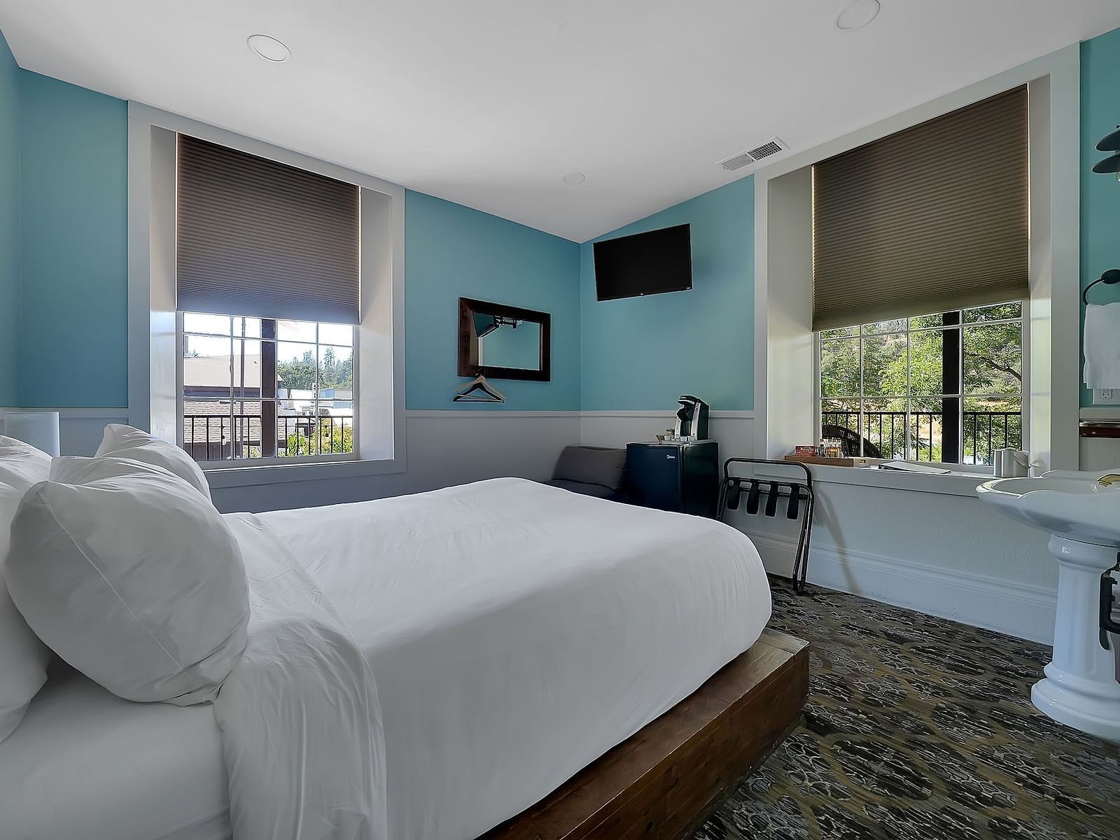 a light blue room at The Groveland Hotel with a double bed and a table.