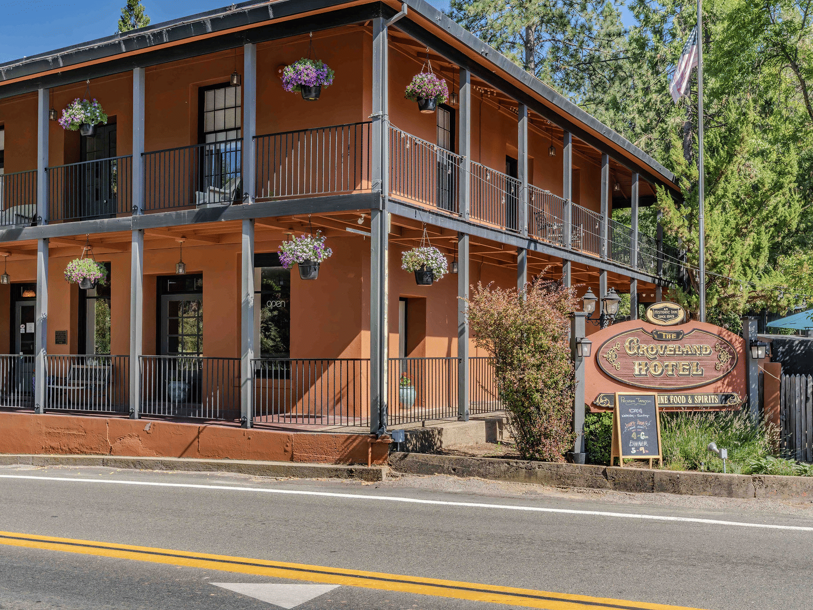 Exterior of a cabin at The Groveland Hotel during the day with the hotel's signage in view.