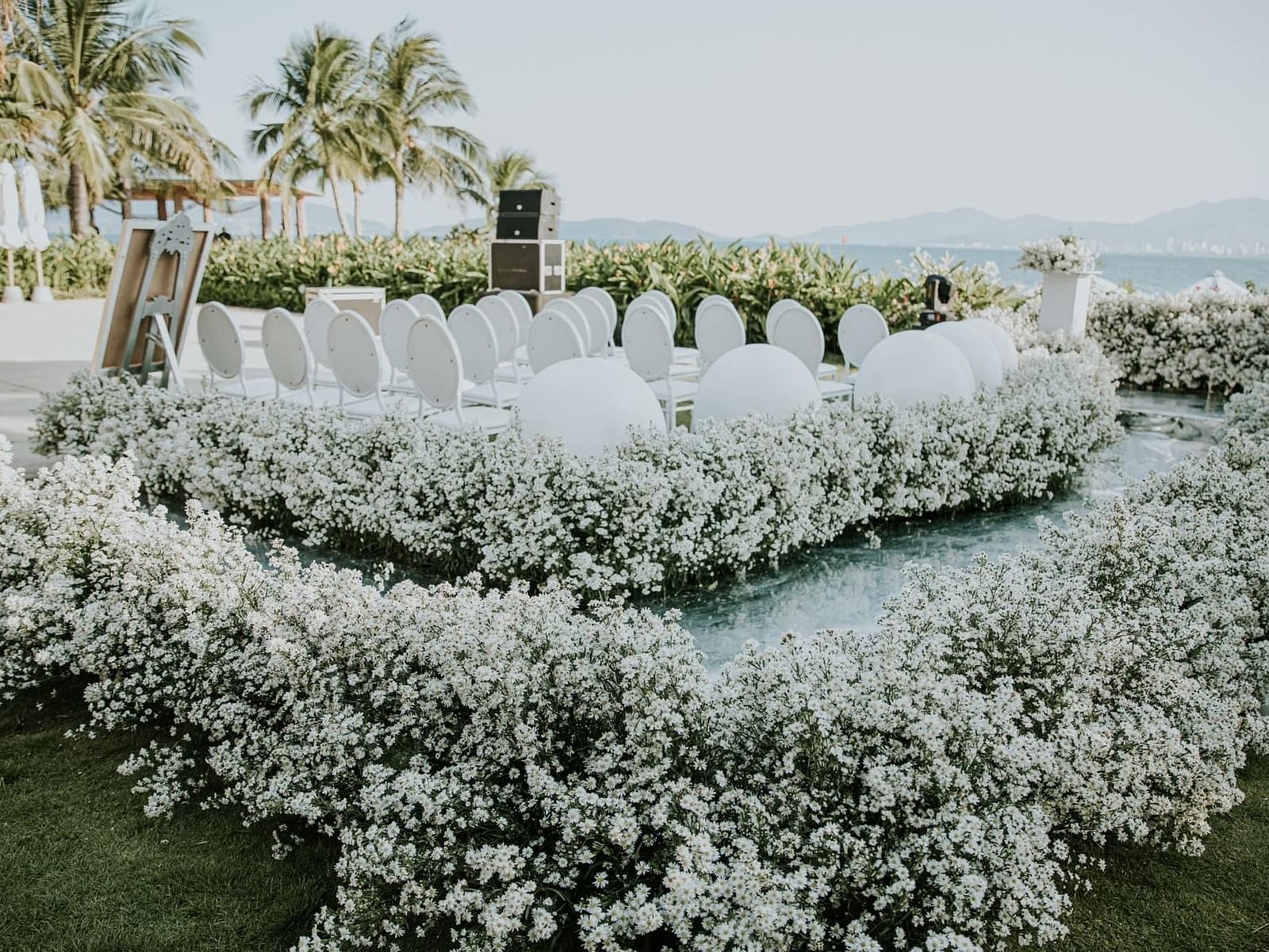 An altar at our lawn surrounded by flowers and chairs placed on an elevated platform - Alibu Resort Nha Trang