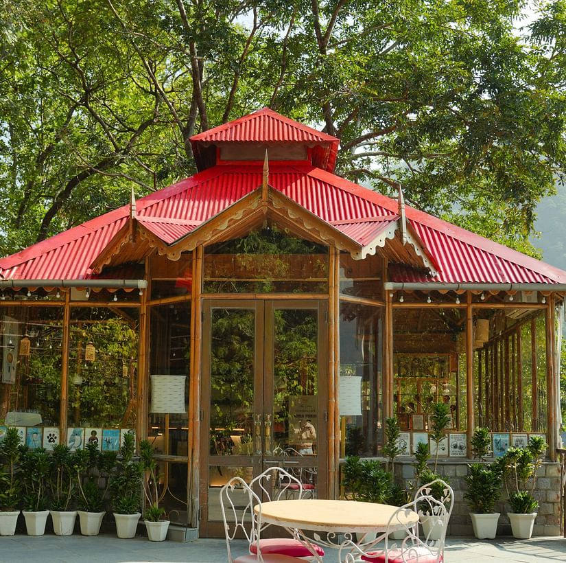 An outdoor gazebo with seating and a view of trees and mountains.