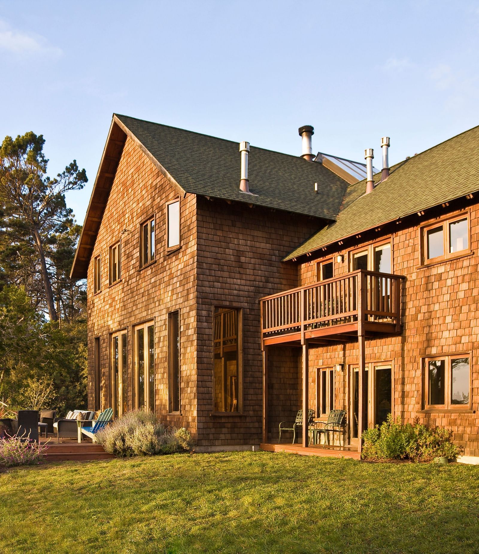 The rear view of Brewery Gulch Inn & Spa with a well manicured lawn and lush green trees