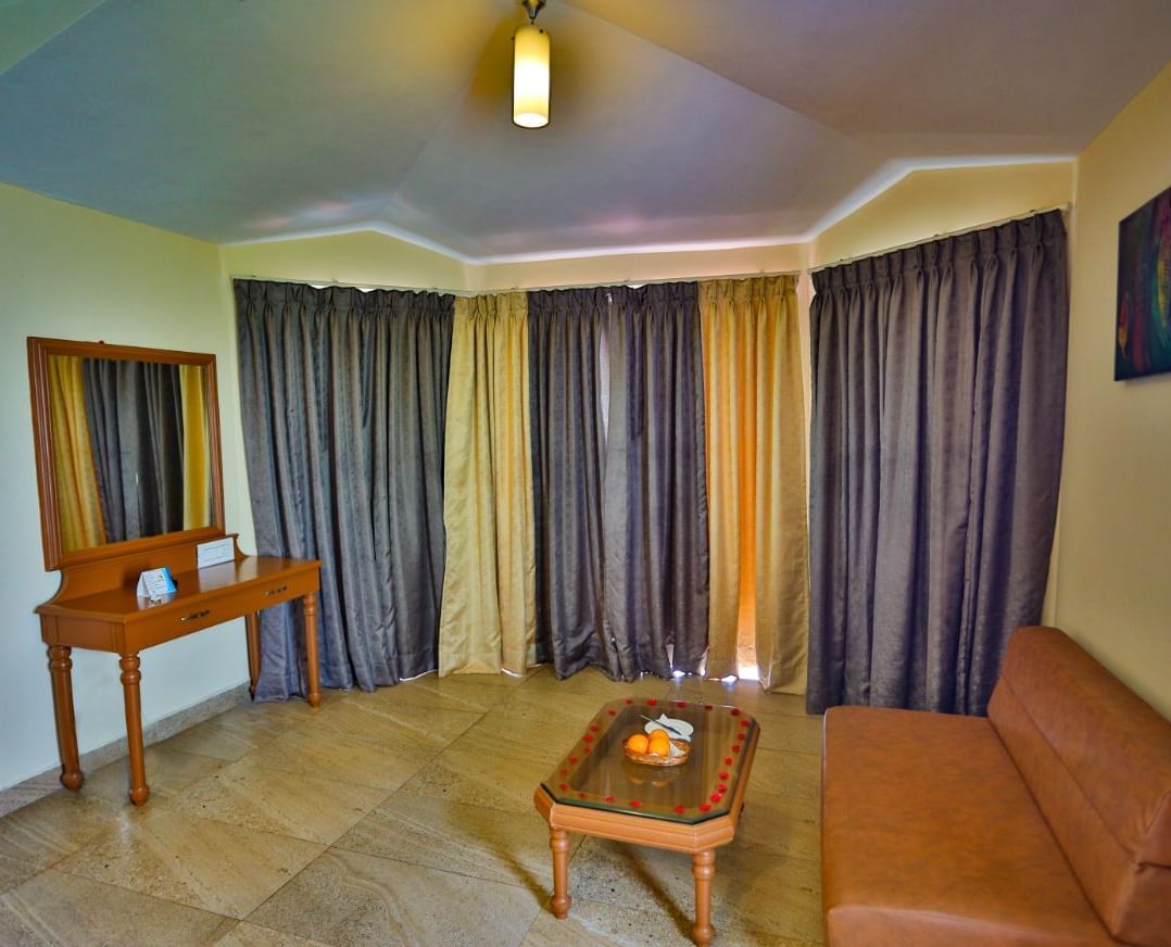 a view of a brown sofa facing a looking glass at La Montana By TGI, Ooty