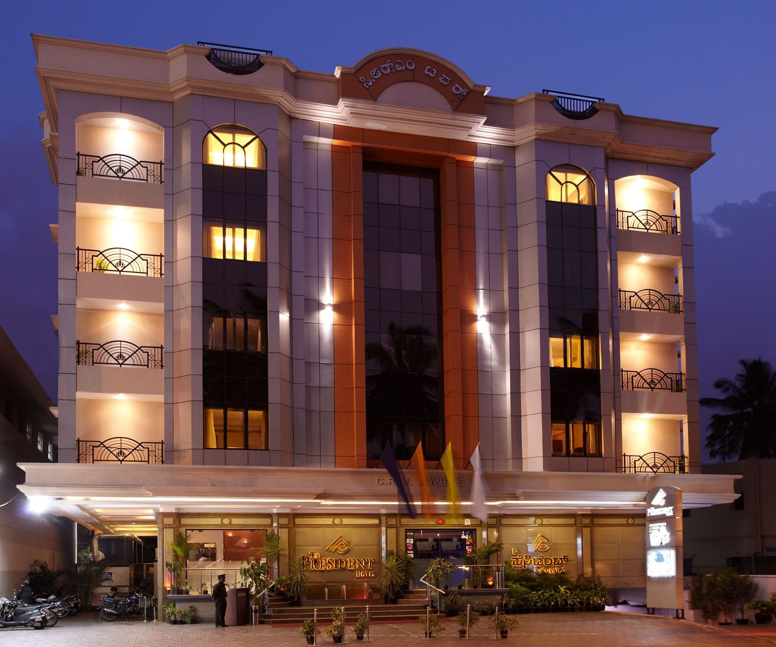 Grand facade of The President Hotel Jayanagar, Bangalore with striking red accents and a majestic entrance, showcasing a blend of traditional and contemporary architecture