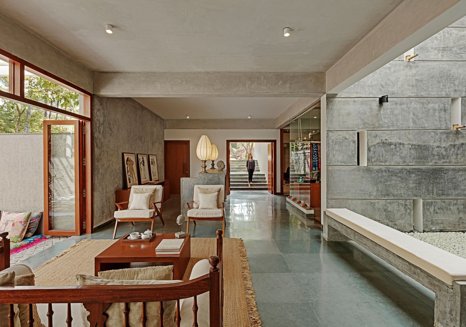 Long hallway with seating and a view of a garden, indoor setting - Shreyas Retreat