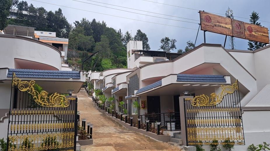 Facade of WOW Naturefull Resorts featuring several villas along with a pathway surrounded by lush greenery.