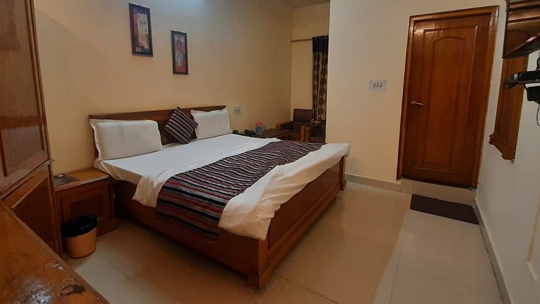 An image of a room in Roorkee with a king size bed, a cupboard and a television - Motel Divine International, Roorkee
