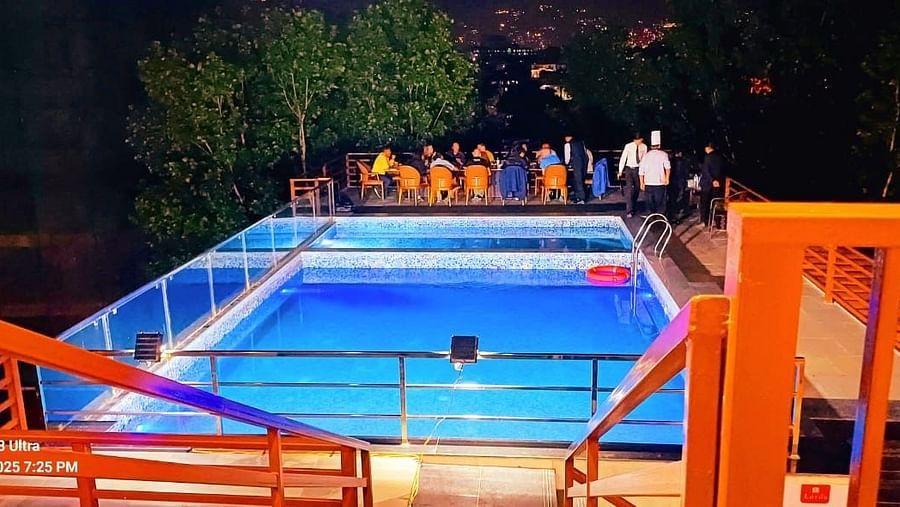 Dining setup for a large group on the patio of the illuminated swimming pool at Mandala Norling Lords Prime, Kathmandu.
