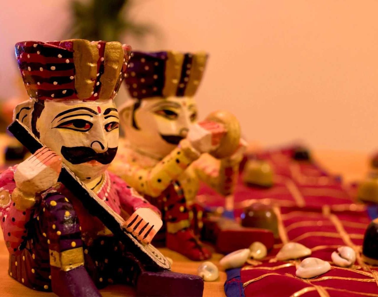 Traditional Rajasthani puppets in vibrant attire displayed as local cultural decor at Jaypore360 Homestay.