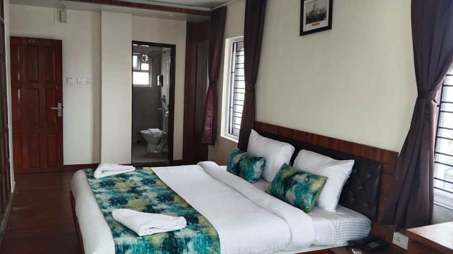 A double bed with towels kept on it inside the Deluxe room