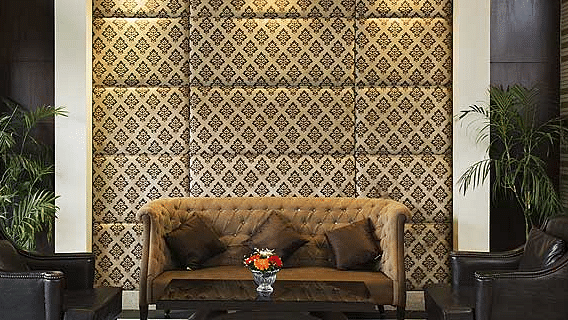A spacious, elegantly designed lobby at The Manor, Bareilly featuring plush seating arrangements with modern armchairs and sofas, soft ambient lighting