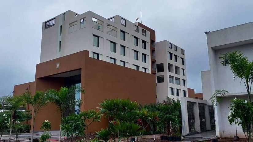 A dutch view of the facade of Pride Resort Ambaji with trees around it