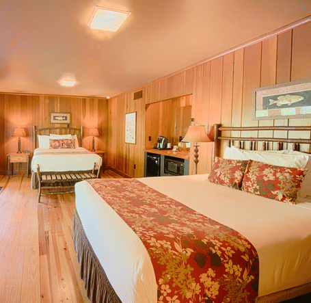 a room with ample of natural light coming from the huge windows featuring two comfortable double beds - Historic Tapoco Lodge