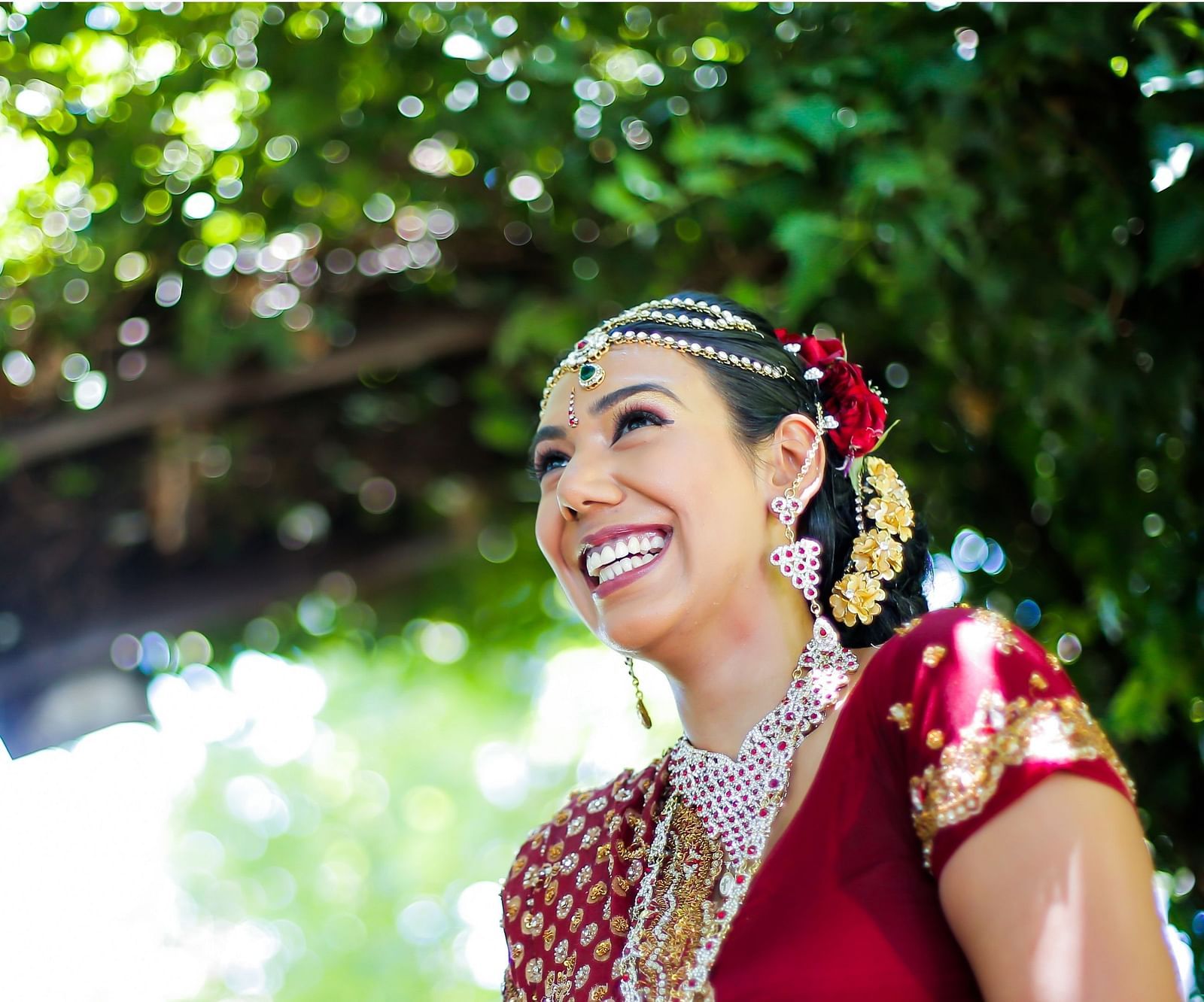 a bride wearing red saree and many jewellery posing for a picture - Rhythm Kumarakom