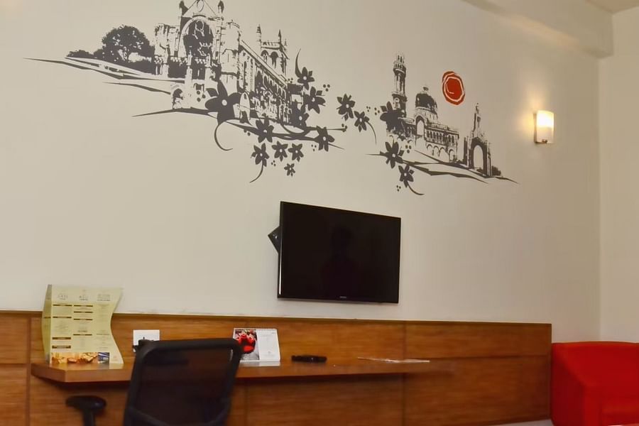 alt-text Artistic wall decor in a hotel room featuring historic architecture illustrations.