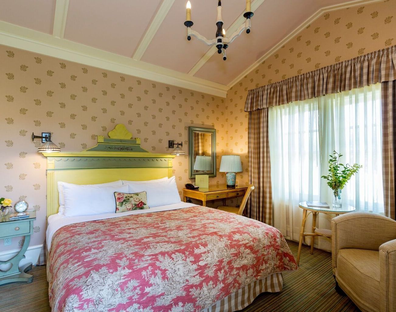 A charming and comfortable guest room at the Tallman Hotel, with a sloped ceiling, a double bed, and elegant decor.